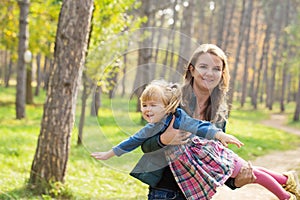 Happy mother playing with his daughter in the park  in summer day