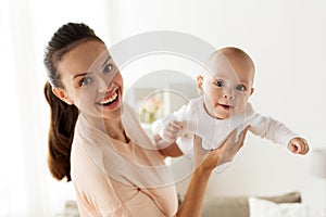 Happy mother playing with little baby boy at home