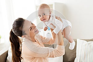 Happy mother playing with little baby boy at home