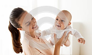 Happy mother playing with little baby boy at home