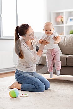 happy mother playing with little baby at home