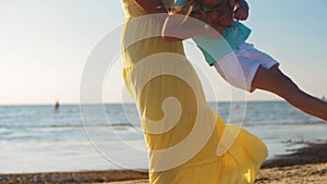 Happy mother playing with little daughter on beach