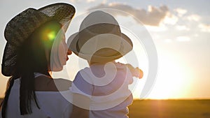 Happy mother playing with little son at sunset. Young caucasian mom and baby boy having fun outdoor in evening.