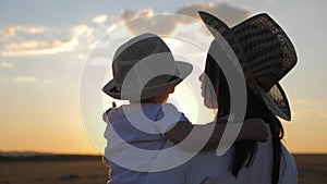 Happy mother playing with little son at sunset. Young caucasian mom and baby boy having fun outdoor in evening.