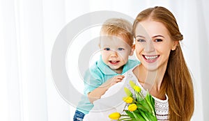 Happy mother`s day. Baby son gives flowers for mom