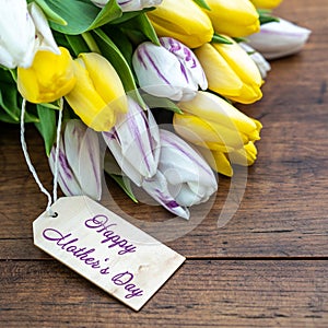 .Happy Mother`s Day background panorama banner - bouquet of flowers with yellow, white / purple tulips and wooden label on a brow