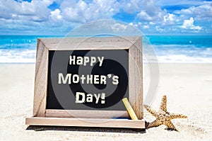 Happy Mother`s day background with starfish and chalk on the sa