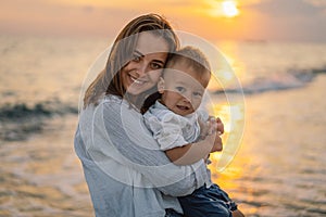 happy mother's day. Beautiful mother and baby play on the beach.