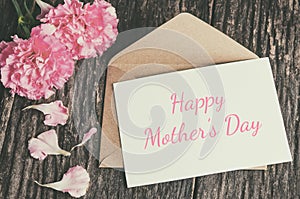 Happy Mother`s Day card with brown envelope and pink carnation f