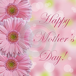 Happy Mother's Day card with three soft light pink gerbera daisy flowers with abstract bokeh background