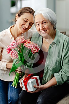 Happy Mother& x27;s Day. The child congratulates her mother and gives her a gift and a flowers