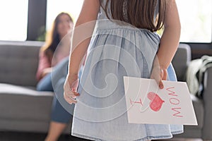 Happy mother`s day! Child daughter congratulates mom and gives her postcard