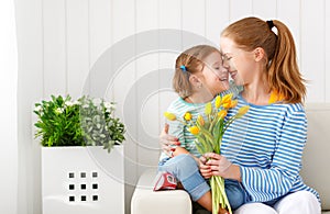 Happy mother`s day! Child daughter congratulates moms and gives