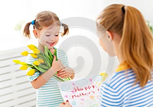 Happy mother`s day! Child daughter congratulates moms and gives