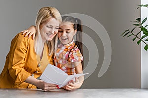 Happy mother's day. Child daughter congratulates moms and gives her a postcard.