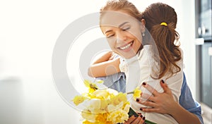 Happy mother`s day! child daughter gives mother a bouquet of f