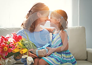 Happy mother`s day! child daughter gives mother a bouquet of f