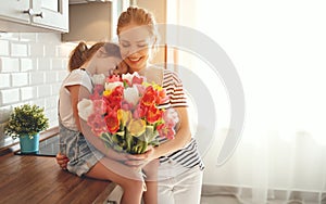 Happy mother`s day! child daughter gives mother a bouquet of f