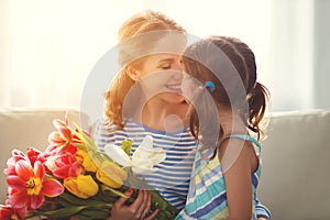 Happy mother`s day! child daughter gives mother a bouquet of f