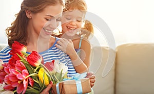 Happy mother`s day! child daughter gives mother a bouquet of f