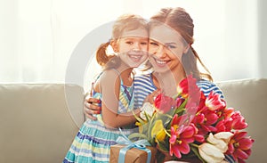 Happy mother`s day! child daughter gives mother a bouquet of f