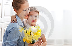 Happy mother`s day! child daughter gives mother a bouquet of f