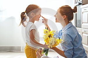 Happy mother`s day! child daughter gives mother a bouquet of f