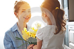 Happy mother`s day! child daughter gives mother a bouquet of f