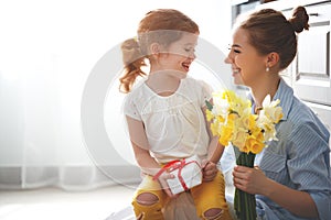 Happy mother`s day! child daughter gives mother a bouquet of f