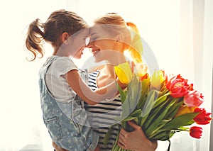 Happy mother`s day! child daughter gives mother a bouquet of f photo