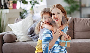 Happy mother`s day! child daughter gives mother a bouquet of flowers to tulip and gift