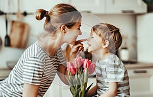 Happy mother`s day! child son gives flowers for  mother on holiday