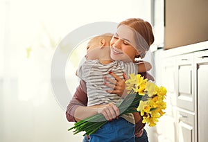 Happy mother`s day! child son gives flowersfor  mother on holiday