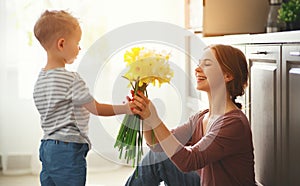 Happy mother`s day! child son gives flowersfor  mother on holiday