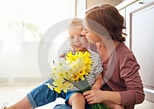 Happy mother`s day! child son gives flowersfor  mother on holiday