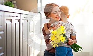 Happy mother`s day! child son gives flowersfor  mother on holiday