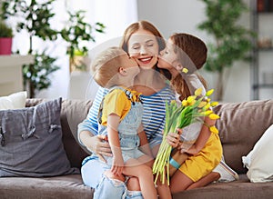 Happy mother`s day! Children congratulates moms and gives her a gift and flowers