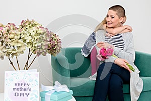 Happy Mother`s Day. Cute little girl congratulating mom to mothers day. Mother and daughter at home. photo
