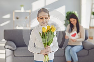 Happy mother`s day. Daughter child gives mother a bouquet of flowers a gift inroom