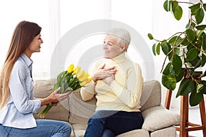 Happy mother`s day. Daughter giving bouquet to mom