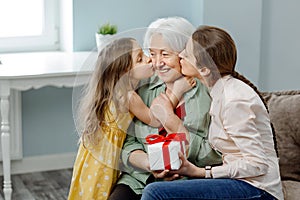 Happy Mother& x27;s Day. Daughter and granddaughter congratulate mother and grandmother, gives her a gift.