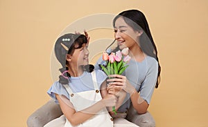 happy mother's day. family Asian mother and daughter congratulates mother and gives a bouquet of flowers to tulips