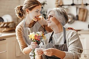 Happy mother`s day! family old grandmother  mother-in-law and daughter-in-law daughter congratulate on   holiday, give flowers