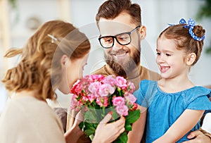 Happy mother`s day! father and child congratulate mother on holiday