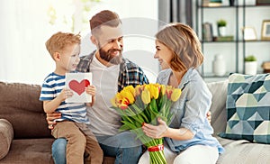 Happy mother`s day! father and child congratulate mother on holiday