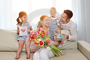 Happy mother`s day! father and children congratulate mother on h