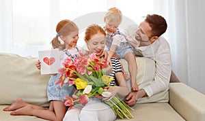 Happy mother`s day! father and children congratulate mother on h