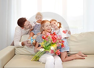 Happy mother`s day! father and children congratulate mother on h