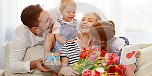 Happy mother`s day! father and children congratulate mother on h