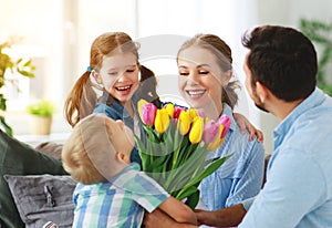 Happy mother`s day! father and children congratulate mother on holiday